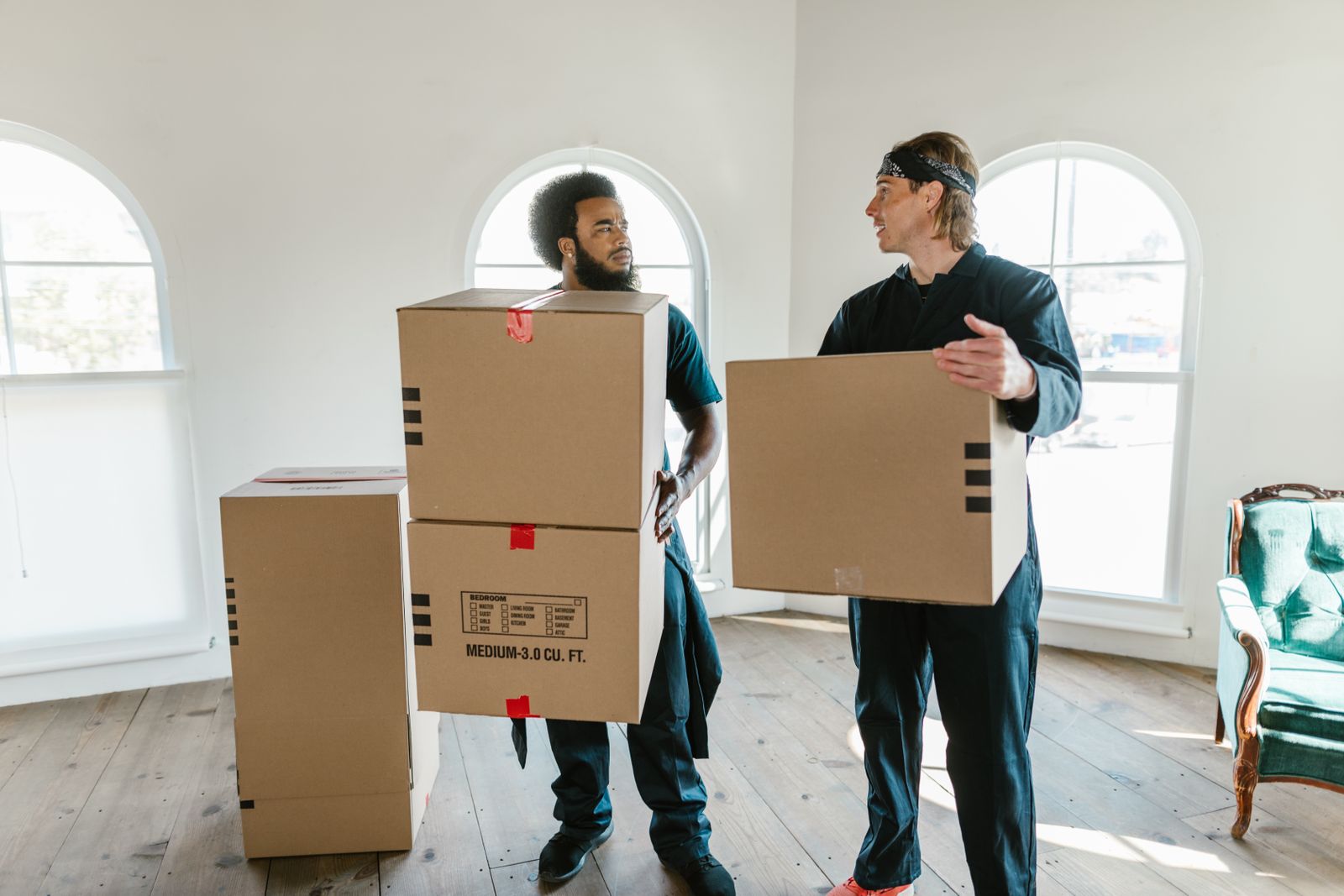 Movers carrying labelled crates into a bright Houston office floor